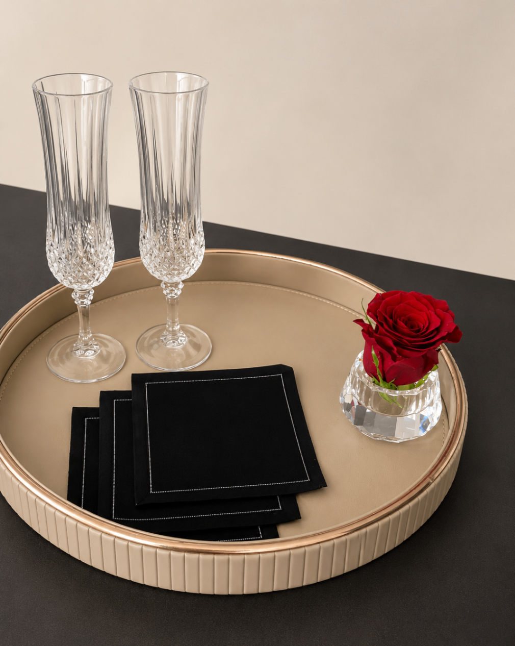 Champagne flutes and rose on gold tray