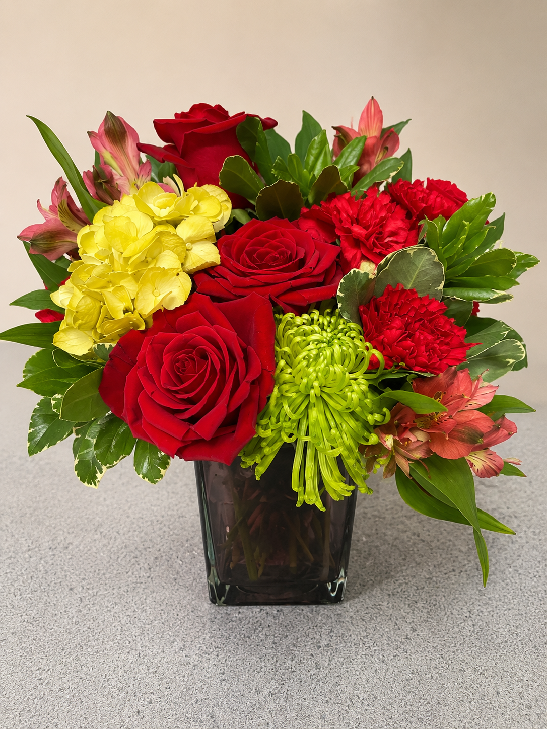 Mixed floral arrangement with red roses, yellow blooms, and greenery