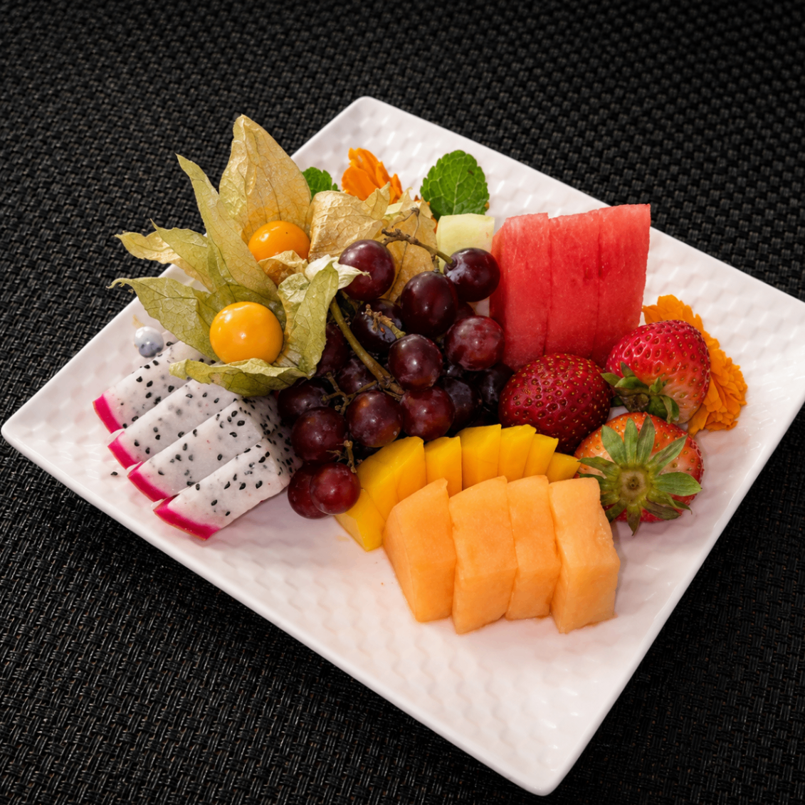 Fresh fruit plate with dragon fruit, melon, and berries
