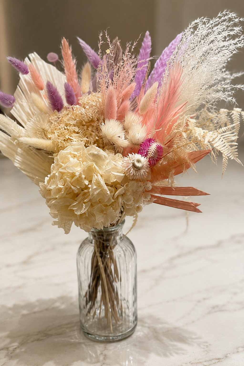 Soft dried floral arrangement in blush, lavender, and ivory tones